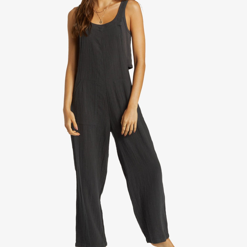 front view of the model wearing the pacific time romper/jumpsuit. shows the straight neckline. also shows the front patch pockets, and the relaxed fit. 