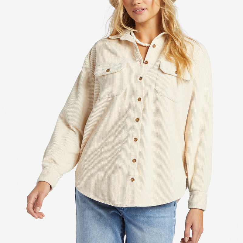 front view of the model wearing the so stoked cord long sleeve top. shows the front button closure. also shows the traditional collar, the two front pockets with flaps and the slight scallop hem 