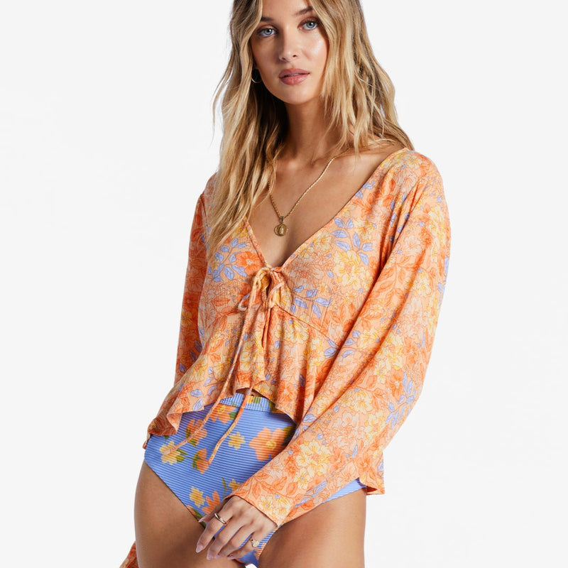 front view od model in blouse. shows the low v-neckline, tie detail and ruffle flouncy hemline.
