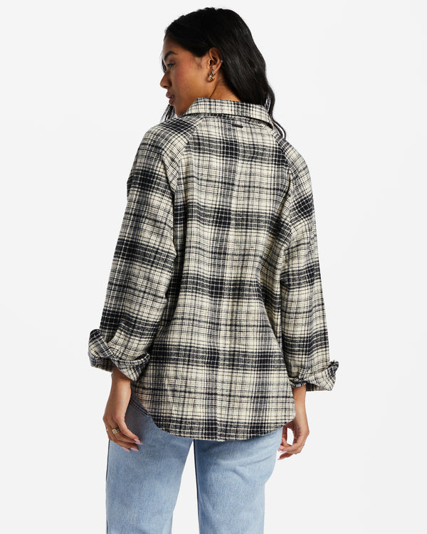 back view of model in flannel. shows collar, raglan sleeves, and curved hemline.