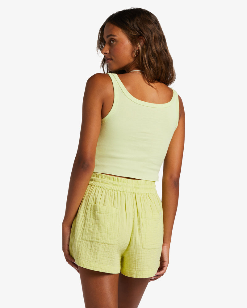 shows back view of model in tank. shows a scooped back and cropped length with raw hemline.