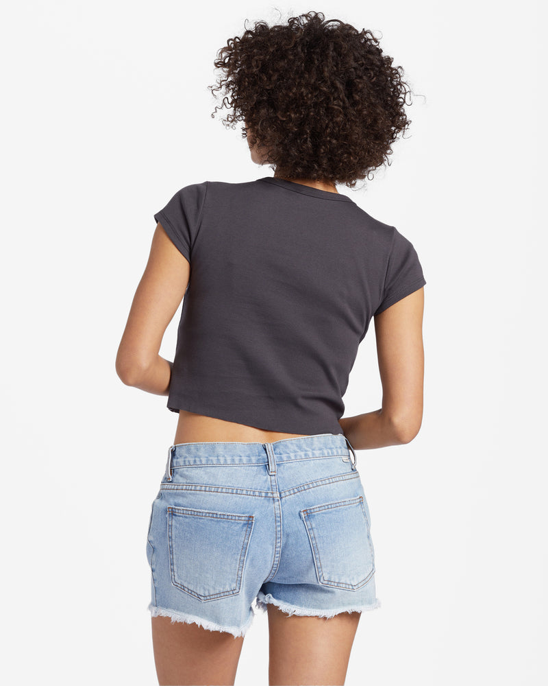 back view of model wearing the live by the sea t shirt. shows the short sleeve. also shows the the t shirt being cropped.  
