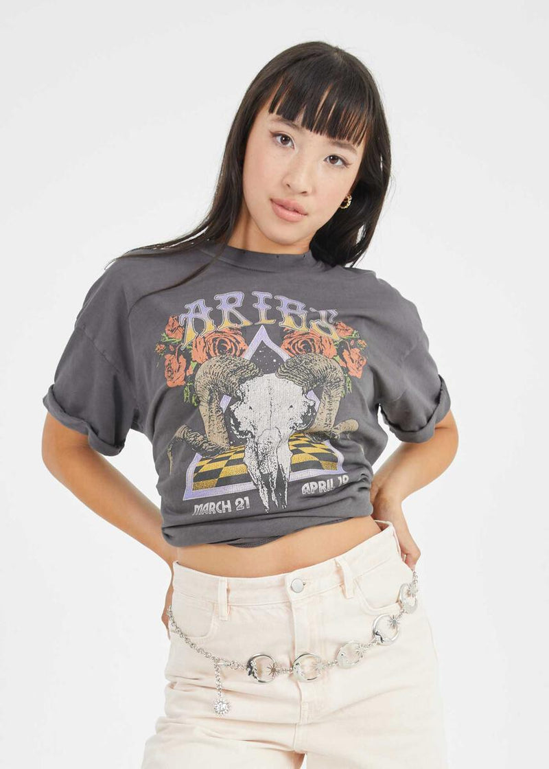 Front view of model wearing tee. Shows the crew neckline. Also shows the cuff sleeves, distressing on neckline and the Aries zodiac graphic. 