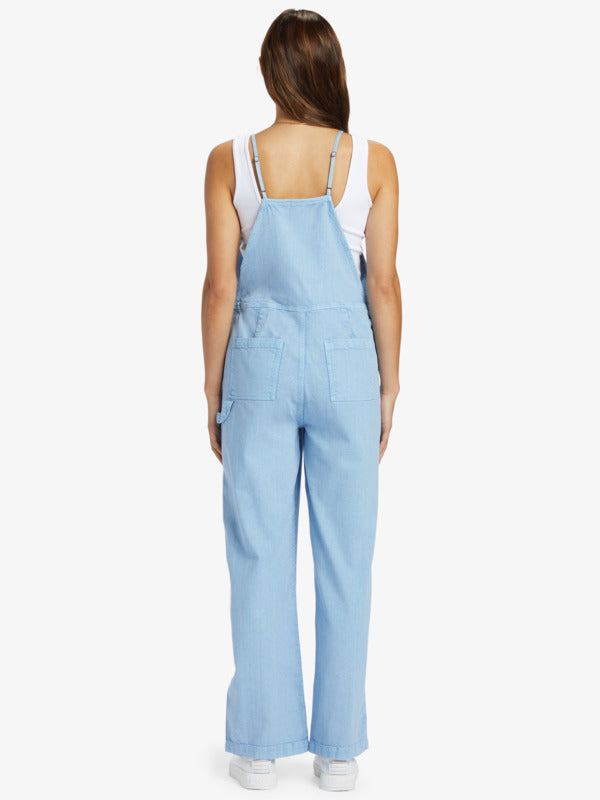 back view of the model wearing the crystal coast overalls. shows the adjustable straps. also shows the back patch pockets and the cargo style pants. 