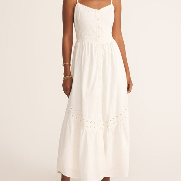 front view of the model wearing the citadelle maxi dress. shows the eyelet detailing. also shows the button detailing, the maxi length, the scoop neckline and the spaghetti straps. 