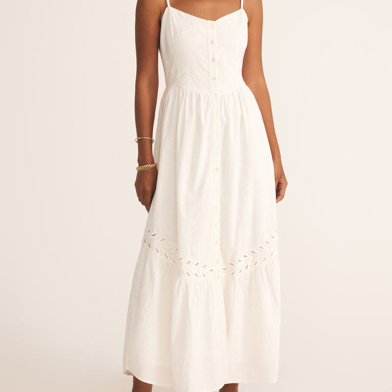 front view of the model wearing the citadelle maxi dress. shows the eyelet detailing. also shows the button detailing, the maxi length, the scoop neckline and the spaghetti straps. 