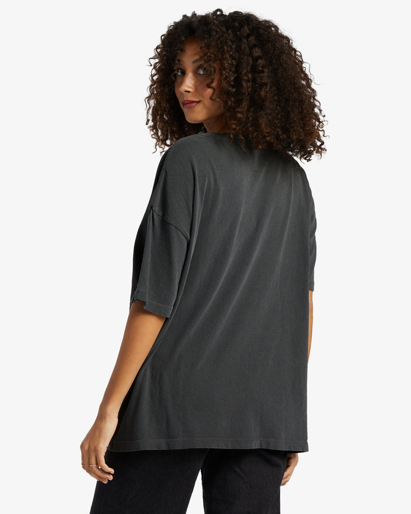Back view of model wearing t shirt. Shows the crew neck. Also shows  short sleeve and the off black color. 