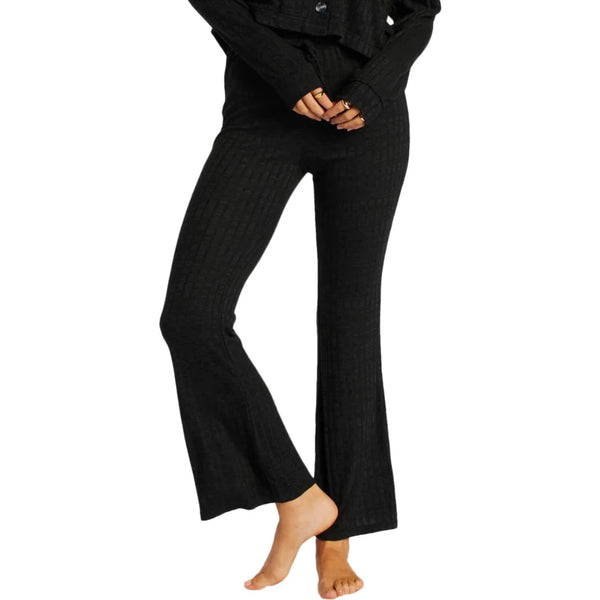front view of model in pants. shows the drawcord waistband and ankle length flare legs.