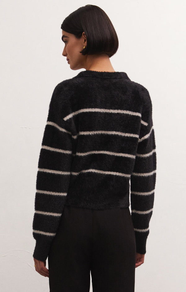 back view of model wearing the Monique stripe sweater in black. shows the drop shoulders. also shows the white strip detail and the relaxed fit. 