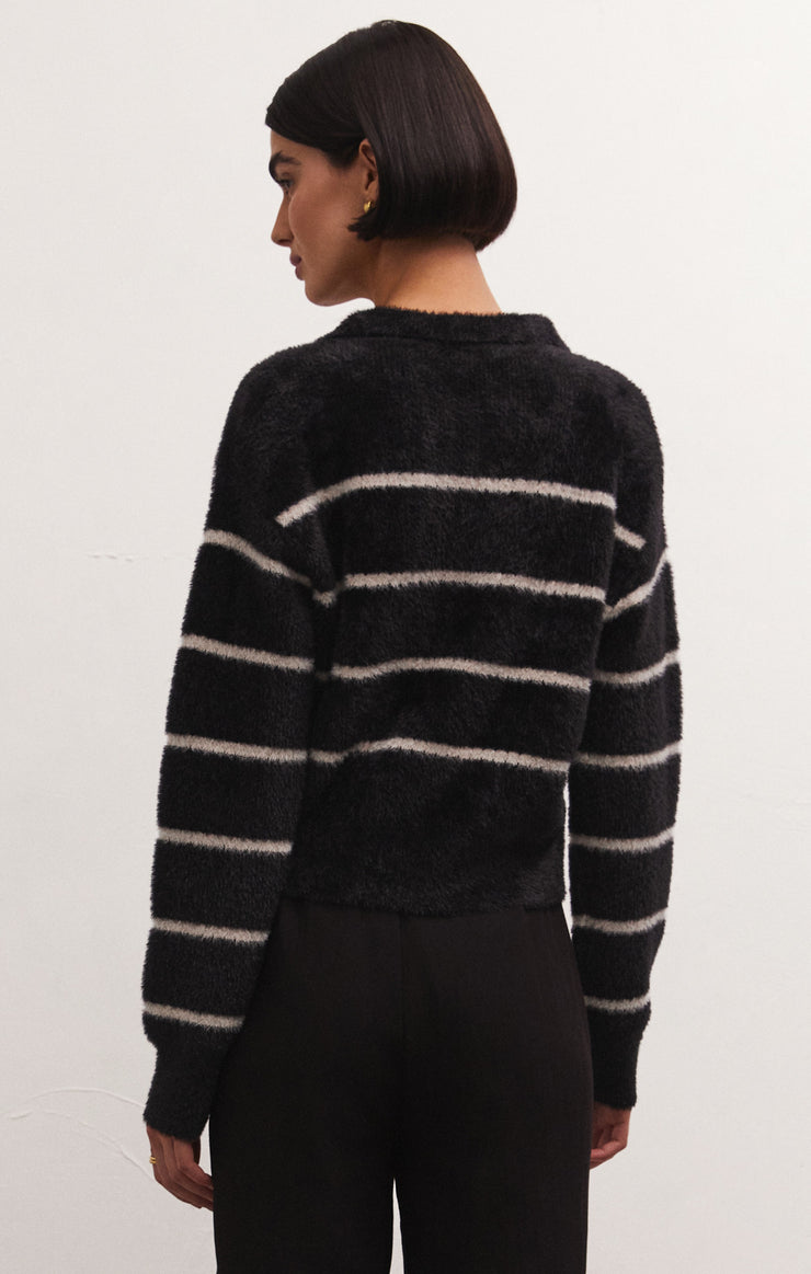 back view of model wearing the Monique stripe sweater in black. shows the drop shoulders. also shows the white strip detail and the relaxed fit. 
