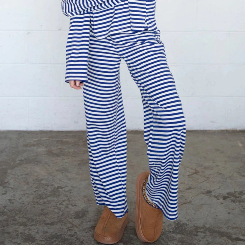 front view of the model wearing the frankie pants. shows the navy and white stripes. also shows the wide leg, the pull on style. 