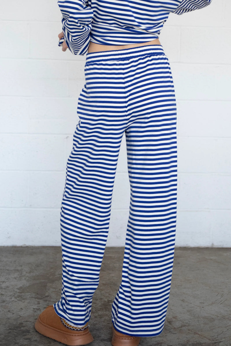 back view of the model wearing the frankie pants. shows the elastic waistband. also shows the pull on style, the navy and white stripes and the wide leg. 