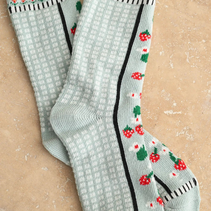 Pair of light blue socks with floral patterns on a beige background