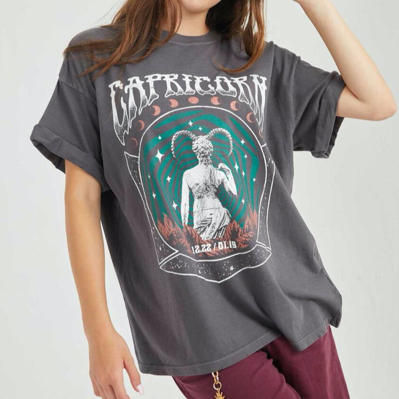 Front view of model wearing tee. Shows the crew neckline. Also shows the cuff sleeves, distressing on neckline and the Capricorn zodiac graphic. 