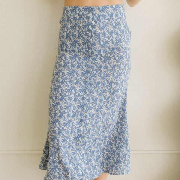 Front view of the model wearing the skirt. Shows the midi length and the button detail down the front. also shows the high waisted waist. 