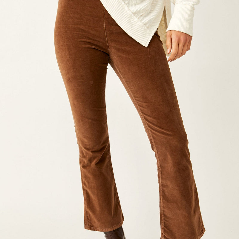 Front view of model wearing the pants. Shows the one leg showing the cropped flare bottom. Also shows the flat front and the color of the pants are this beautiful chocolate color. 