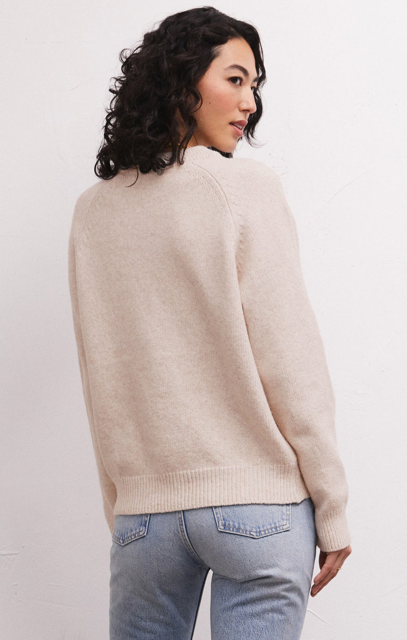 Back view of model wearing sweater. Shows the ribbing detail on the bottom hem and cuffs. 