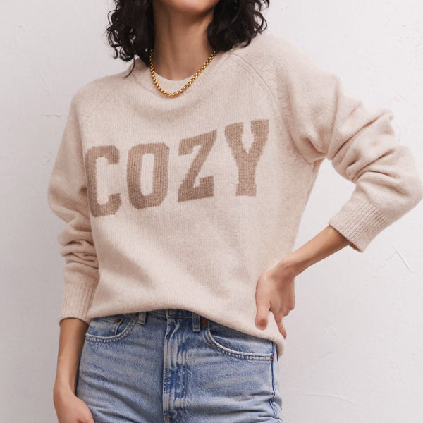 Front view of model wearing sweater. Shows the oversized, relaxed fit. Also shows the crew neckline and the "COZY" instaria lettering on chest. 