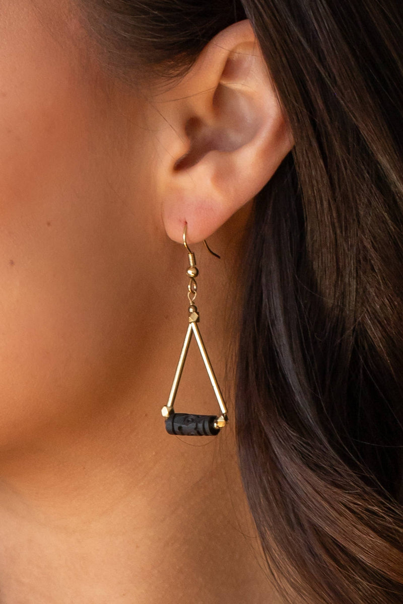 front view of the model wearing the dangle triangle earring. shows the black bead on it, shows the triangle shape & that it is a dangle earring.