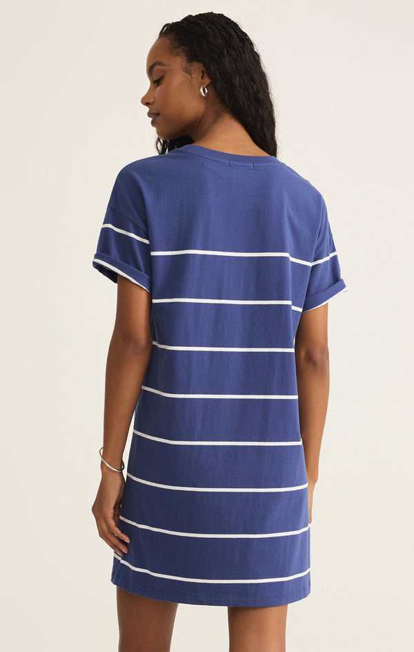 back view of the model wearing the sway stripe mini dress. shows the midi length. also shows the rolled cuff on the arms, the white stripes and the short sleeves. 