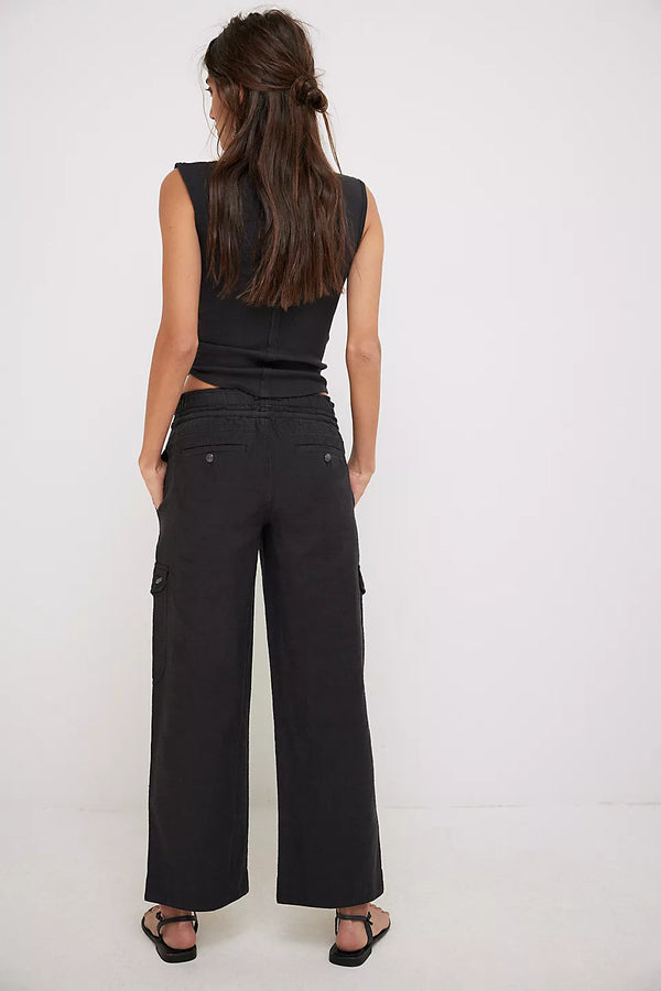 back view of the model wearing the park ave pant in black. shows the slight flare bottom. also shows the slim fit, the multiple pockets. 