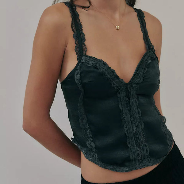front view of the model wearing the tell me more cami in black. shows the lace detailing. also shows the semi cropped, the v neckline. 