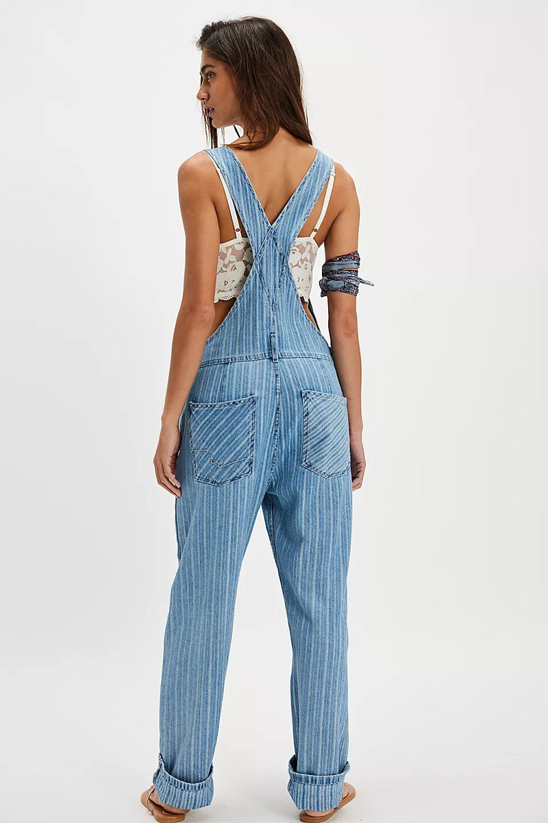 back view of the model wearing the ziggy overalls. shows the back patch pockets. also shows that they are cuffed in the picture, the striped detailing and the tapered legs. 