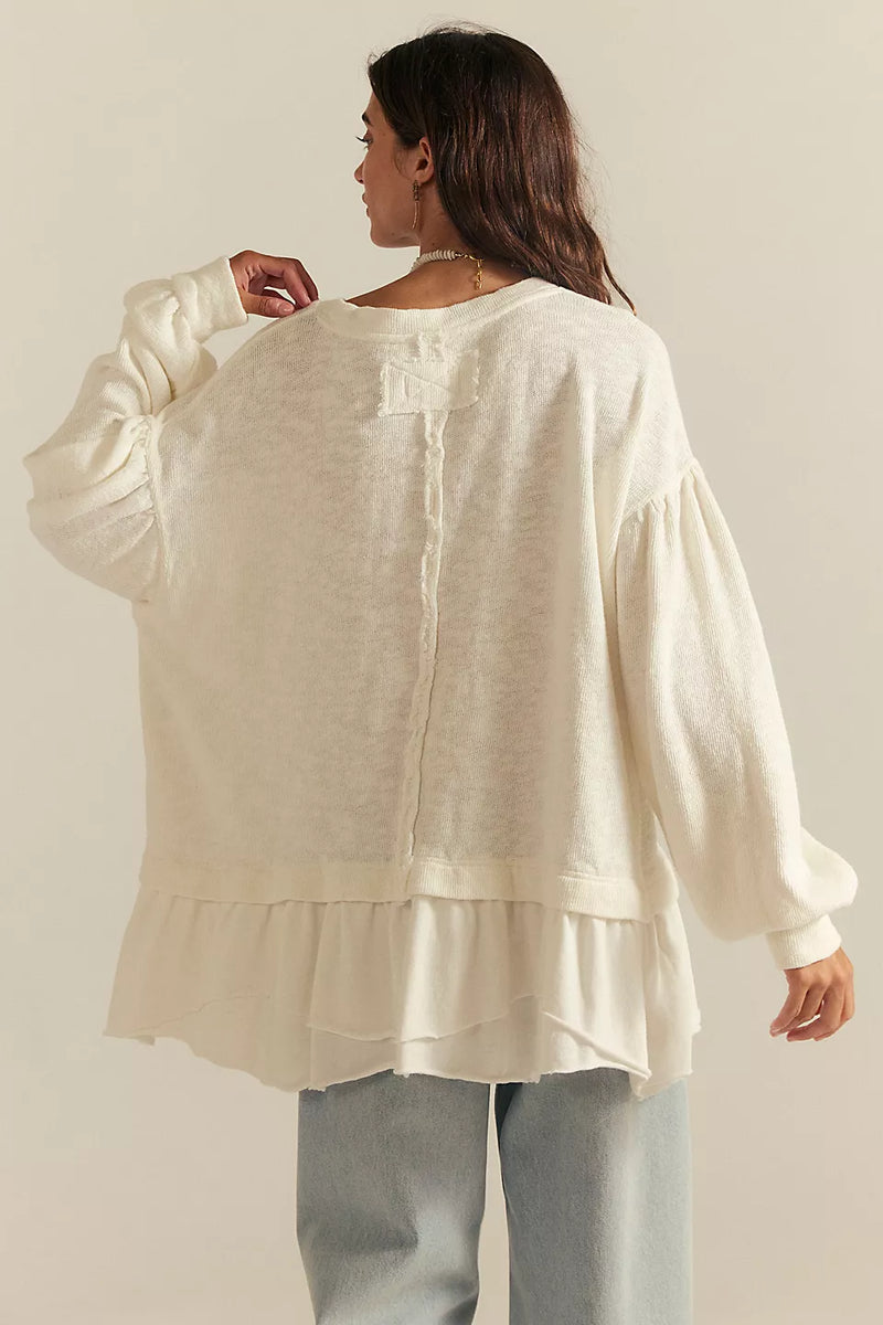 Woman wearing a cream-colored blouse with a plain background