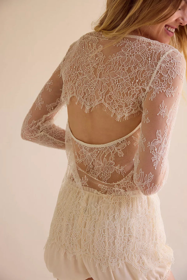 Lace nightgown with long sleeves and open back on a plain background