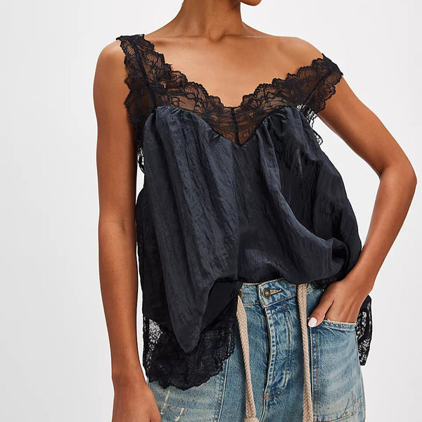 Woman wearing a black lace top and blue jeans on a white background