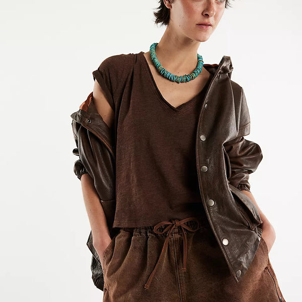 Woman wearing a brown outfit with a leather jacket on a white background