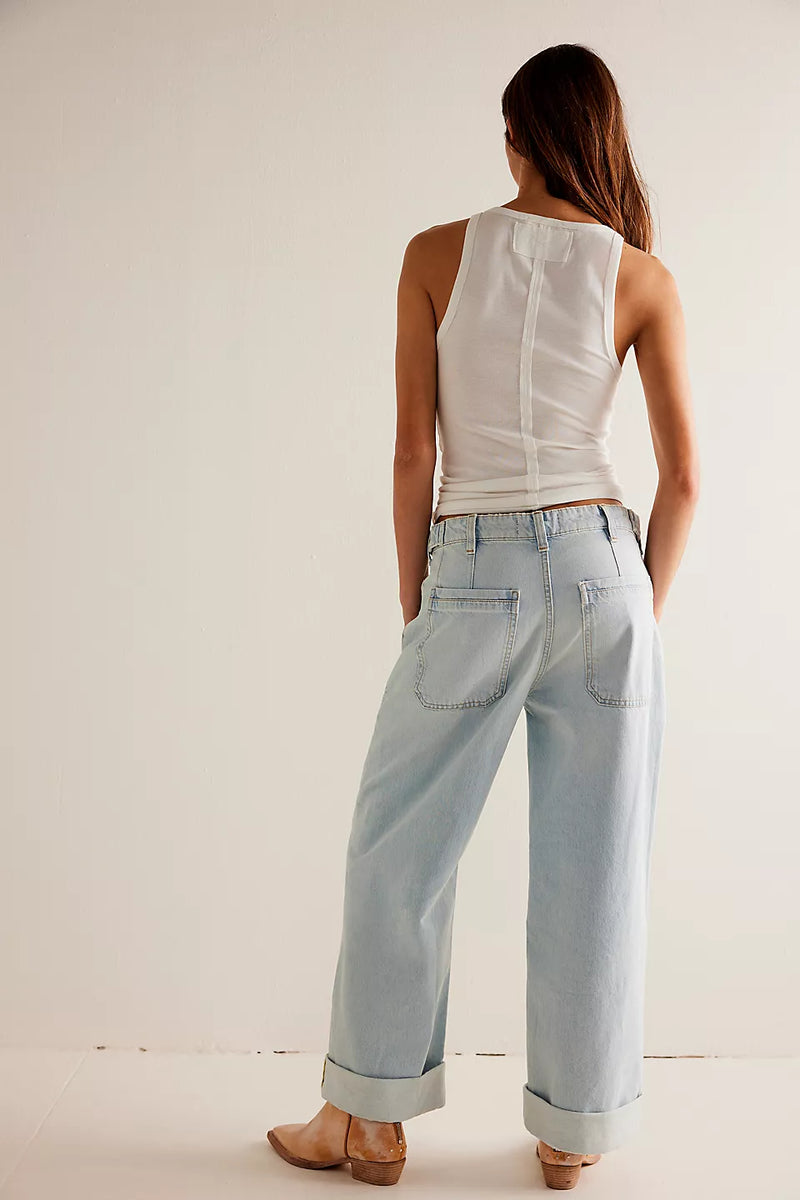 back view of the model wearing the palmer cuffed jeans. shows the cuffed bottom hems. also shows the light color blue denim, the patch pockets and the detailed seaming. 