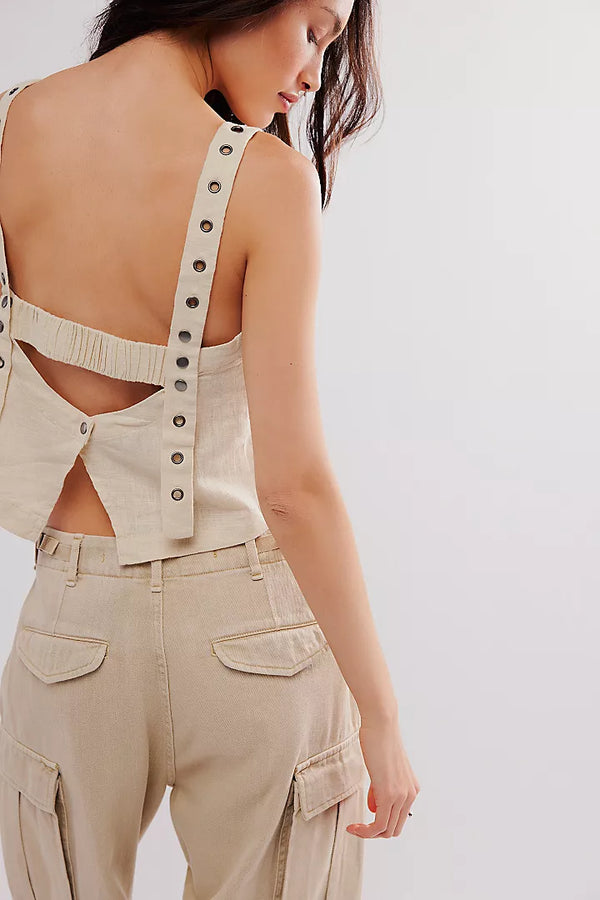 back view of the model wearing the syd grommet tank. shows the open back with a button closure. also shows the grommet adjustable wide straps and the cropped length. 