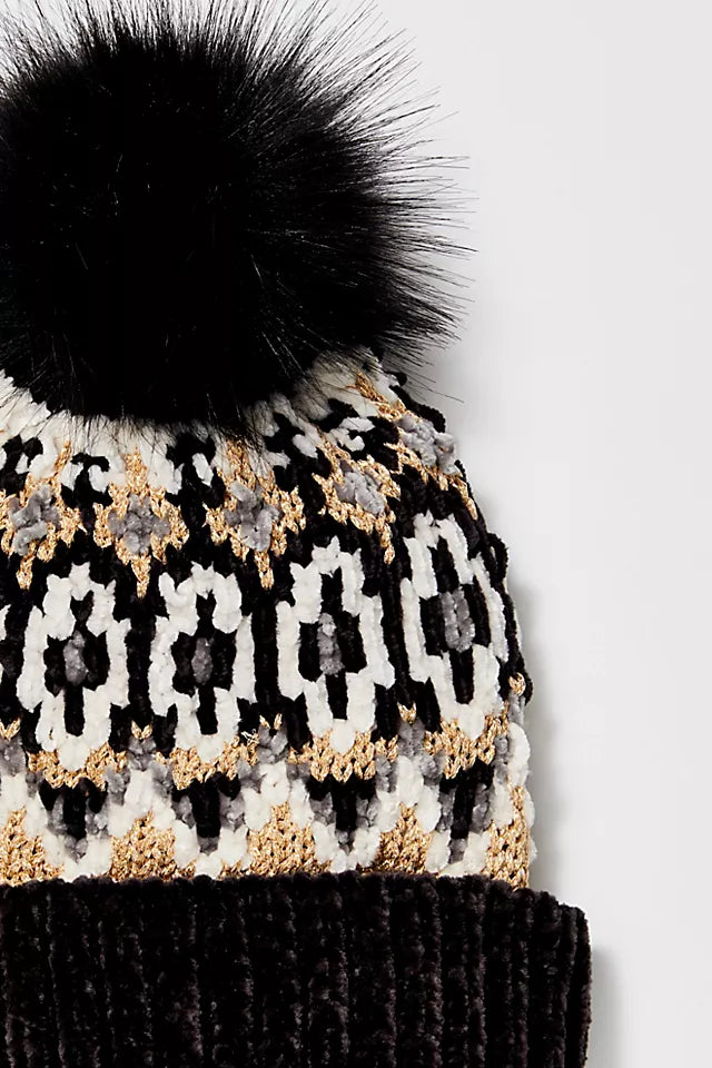 Up close front view of pom beanie. Shows the Chunky knit fabric. Also shows the fair isle print all over, the faux fur pom detail, ribbed trim, wide cuff and the slouchy design. 