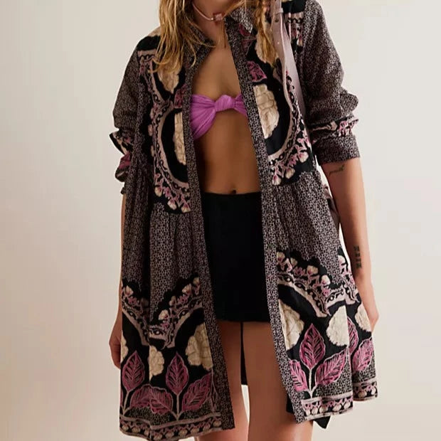 front view of model wearing the mini dress open, paired with a bralette and shorts underneath. you can see the collar, long sleeves rolled up, and the mini legnth.