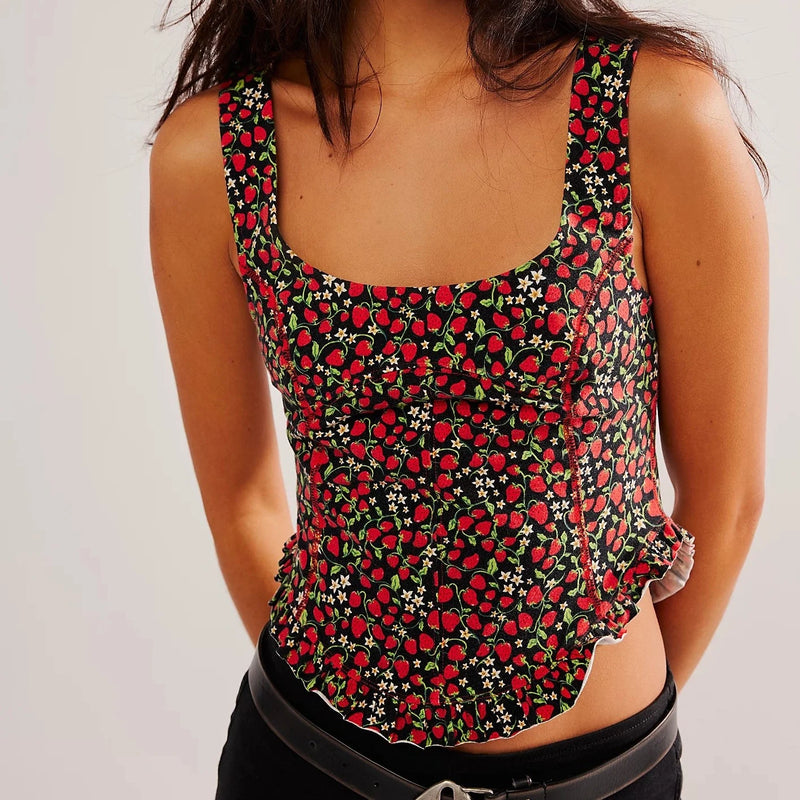 front view of the melanie tank. shows the fun strawberry print. also shows the low scoop neckline, the rounded hem, the exposed seaming and the ruffle bottom. 