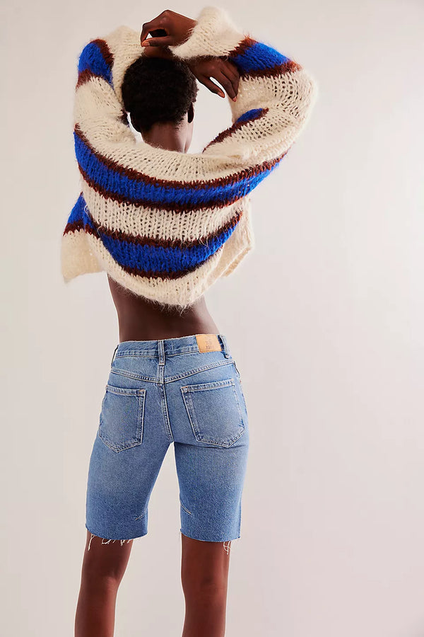 back view of the model wearing the ghost town long short. shows the back pockets. also shows the bottom raw hems, the mid rise and the belt loops. 