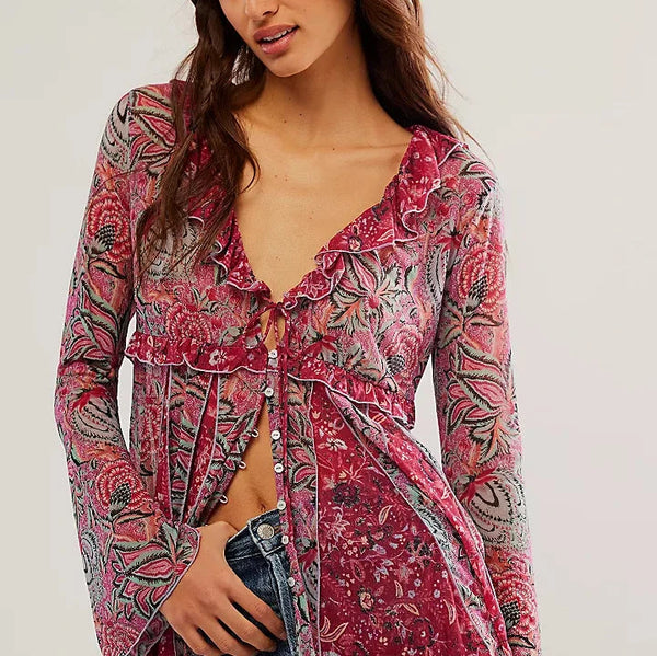 front view of the model wearing the wildest dreams tunic. shows the v neckline. also shows the button down closure, the swingy silhouette, bell sleeves and ruffle trim. 