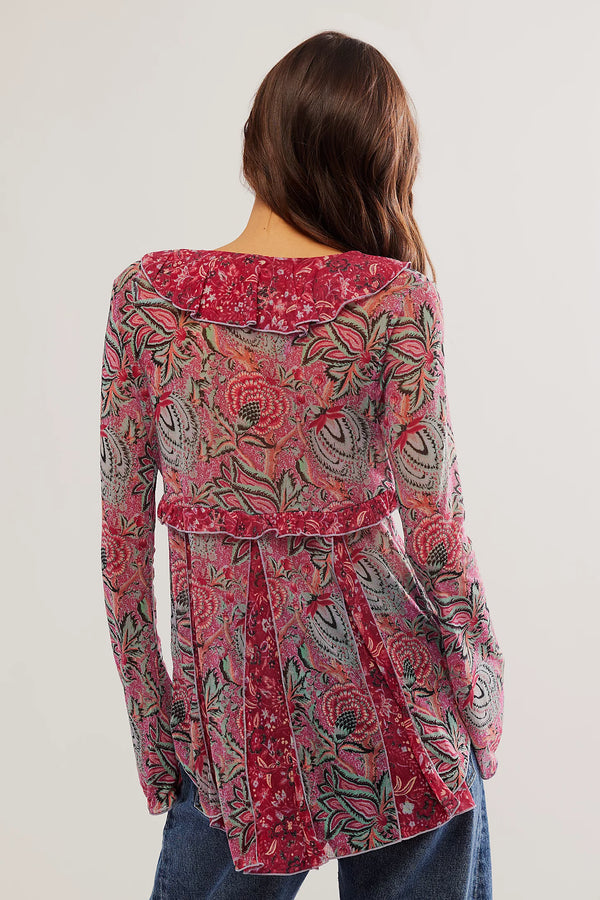Back view of the model wearing the wildest dreams tunic. shows the ruffle trim. also shows the all over print, the swingy silhouette and the bell sleeves. 