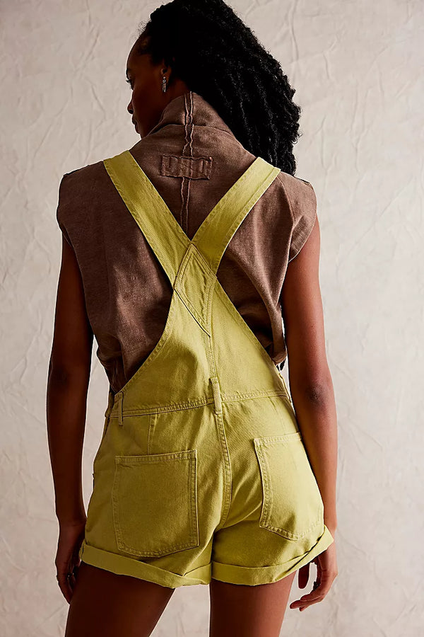 back view of the model wearing the ziggy shortalls. shows the back pockets. also shows the rolled hems, the belt loops and the straps. 
