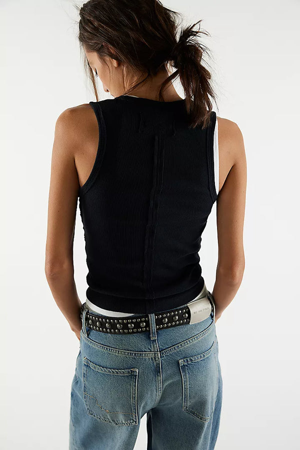 back view of the model wearing the neria tank. shows the dropped armholes. also shows the slim fit and black color. 