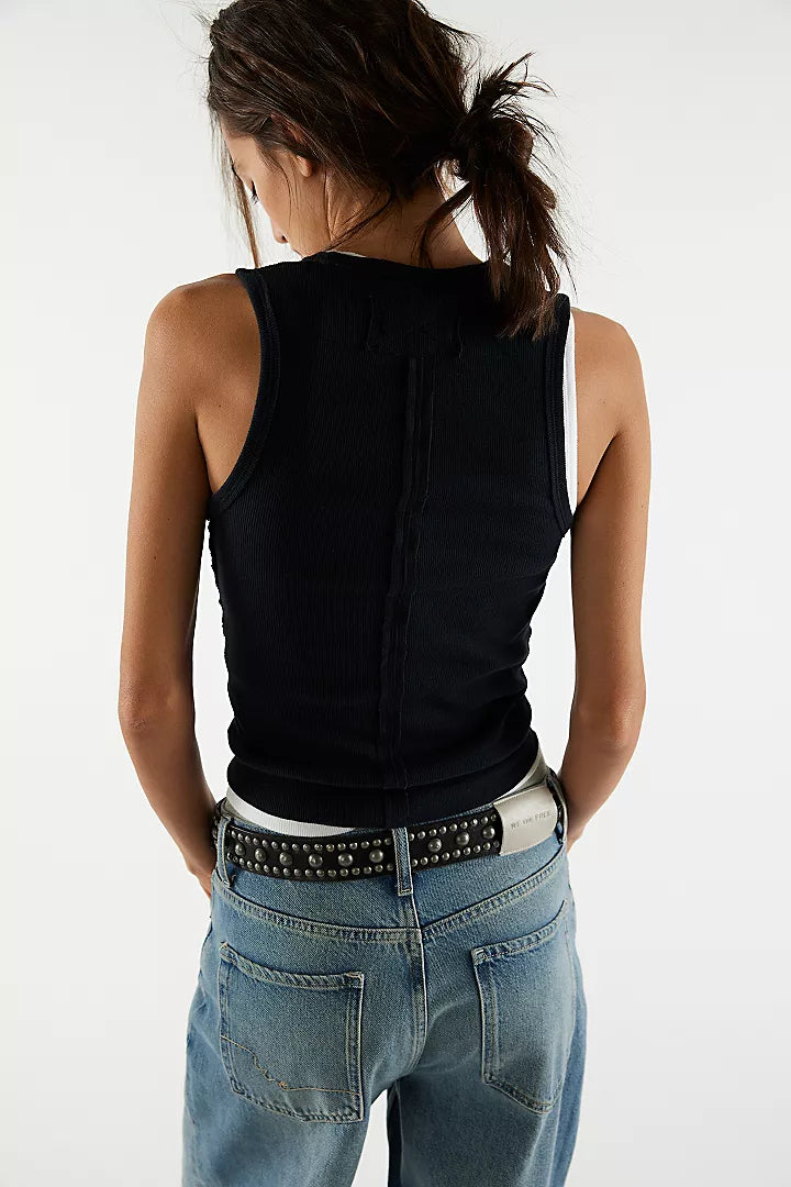 back view of the model wearing the neria tank. shows the dropped armholes. also shows the slim fit and black color. 