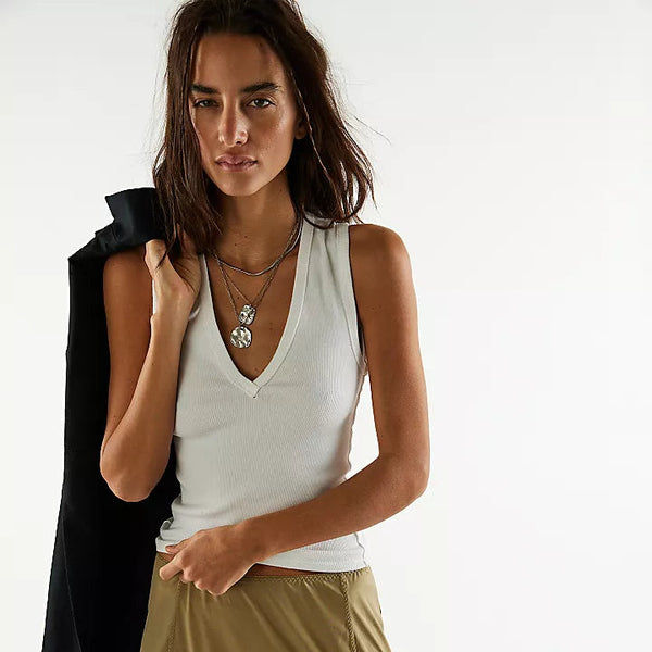 front view of the model wearing the neria tank. shows the deep v neck. also shows the slim fit, the wide straps and raised seams. 