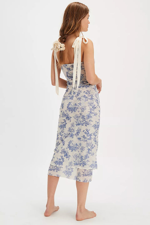back view of the model wearing the got glam slip dress. shows the adjust able straps. also shows the floral pattern, the midi length and the shapeless silhouette.  