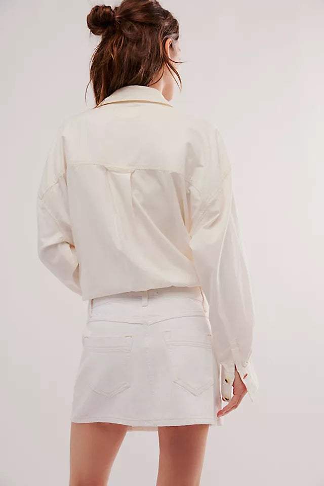 back view of the model wearing the wynne denim skirt. shows the back patch pockets. also shows the defined seaming and the mid rise. 