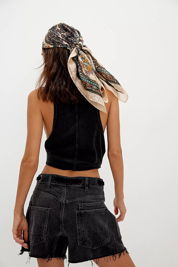 back view of the model wearing the moxie shorts. shows the raw edge hem. also shows the high waist, the black color and the drawstring detail. 