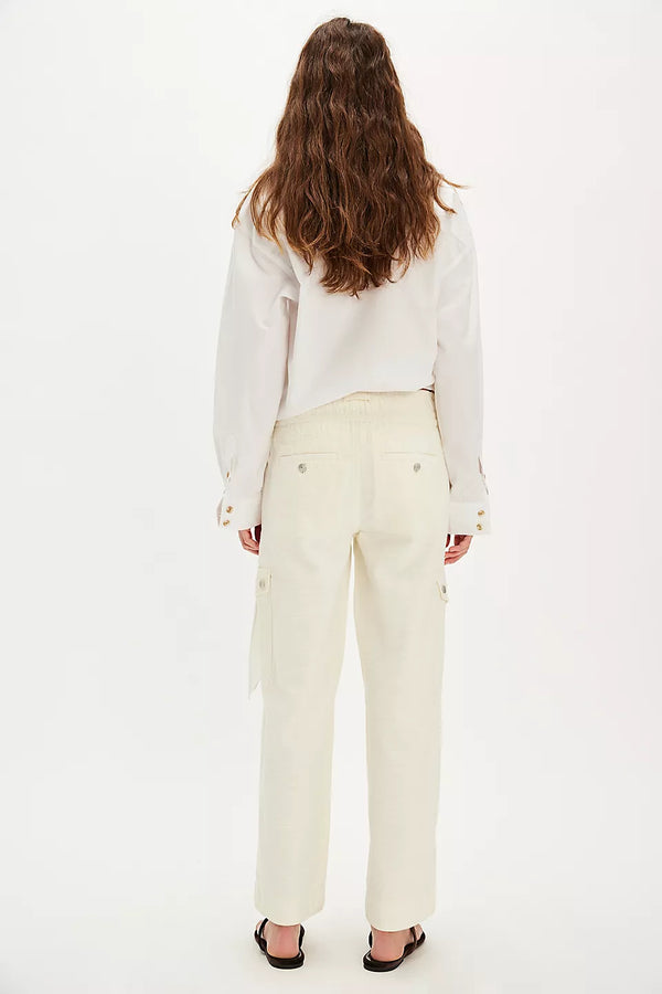 back view of the model wearing the park ave pants. shows the back pockets. also shows the straight legs and the ivory color. 