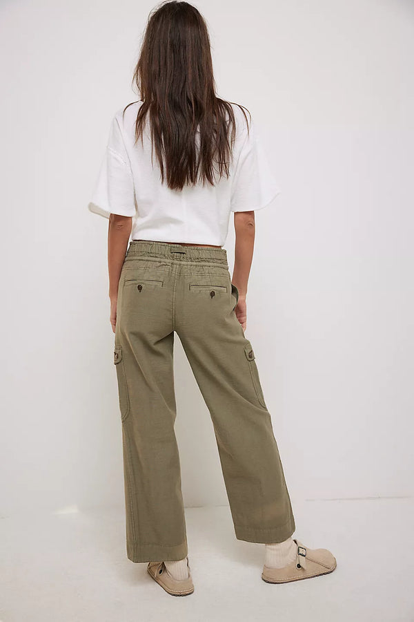 back view of the model wearing the park ave pant. shows the straight leg. also shows the olive green color, and the back pockets. 
