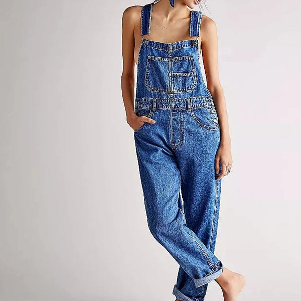 front view of the model wearing the ziggy denim overalls. shows the relaxed, slouchy silhouette. also shows the bib and brace features, the rigid denim fabric and the multiple pockets. 