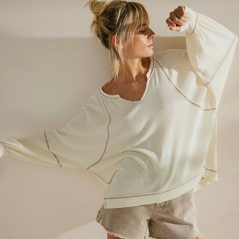 front view of the model wearing the wish i knew tee. shows the v neckline. also shows the dropped shoulders, the exposed seaming and the slouchy oversized fit. 